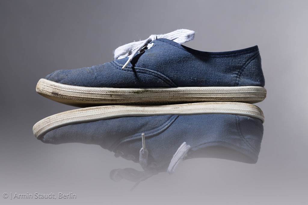 old, blue sneakers with gray background
